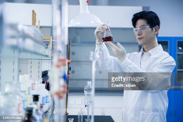 研究室で働くアジア人男性科学者 - リサーチ ストックフォトと画像