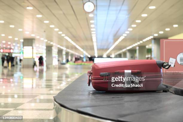 luggage on conveyor belt at airport - zona de equipajes fotografías e imágenes de stock