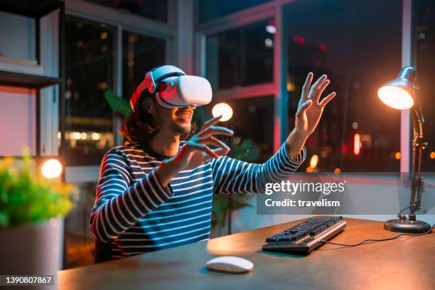 giovane uomo maschio asiatico creativo che indossa occhiali virtuali intelligenti e si unisce alla riunione di lavoro sullo spazio di lavoro del metaverso della realtà aumentata, l'uomo asiatico che utilizza un auricolare vr per esplorare la videoconferen - occhiali da aviatore foto e immagini stock