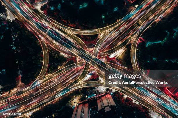 drone point view of overpass and city traffic at night - intersection stock pictures, royalty-free photos & images