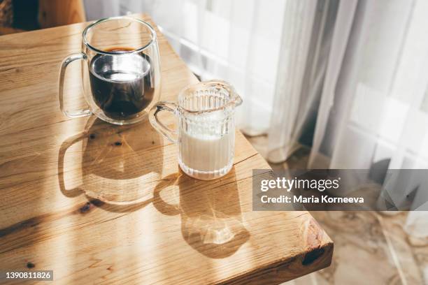 latte coffee in a glass at wooden table. - enjoying coffee cafe morning light stock pictures, royalty-free photos & images