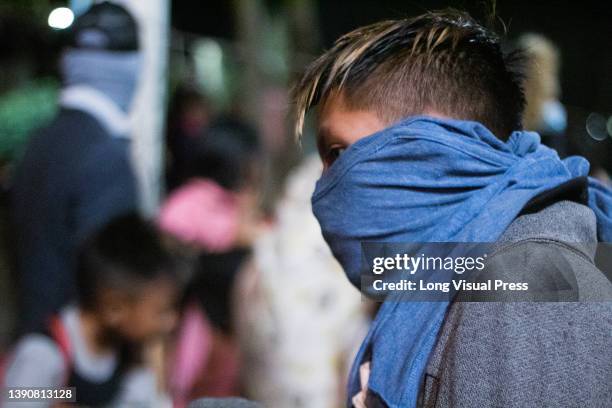 Young member of the Embera indigenous community covers his face as clashes started after several hours of protest blocking the 7th avenue in Bogota,...