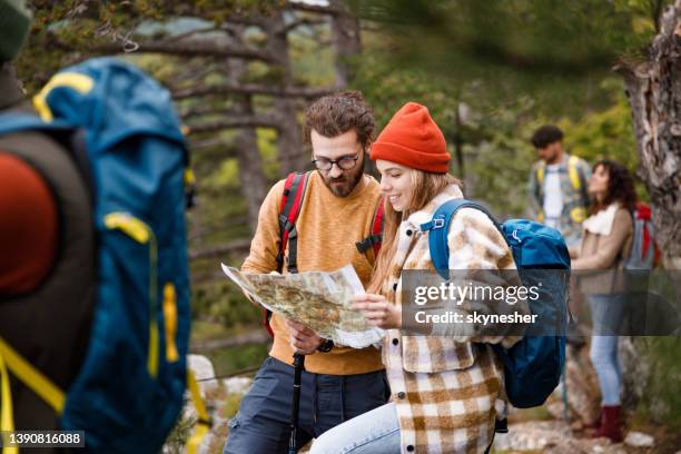 junge wanderpaare lesen eine karte im wald. - orientierungslauf landkarte gruppe stock-fotos und bilder