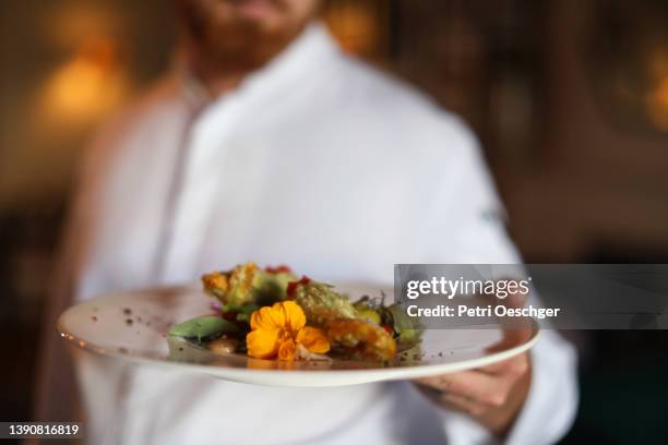 the head chef at a gourmet restaurant preparing for dinner service. - chic stockfoto's en -beelden