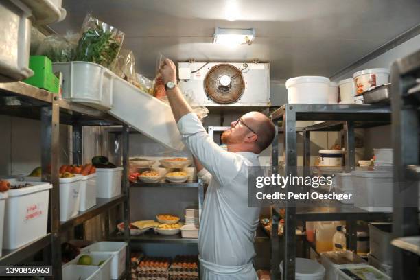 the head chef at a gourmet restaurant takes stock before dinner service. - koelkast stockfoto's en -beelden