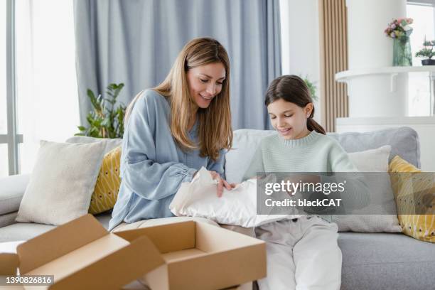 mutter und tochter packen ihr online-lieferpaket aus - geschenk auspacken stock-fotos und bilder