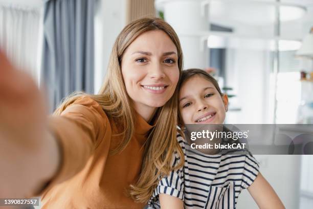 ritratto di madre e figlia carina che scatta un selfie a casa - teen webcam foto e immagini stock