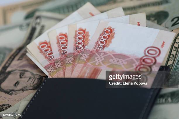 russian banknotes against blurred us paper currency background - tax penalty stock pictures, royalty-free photos & images