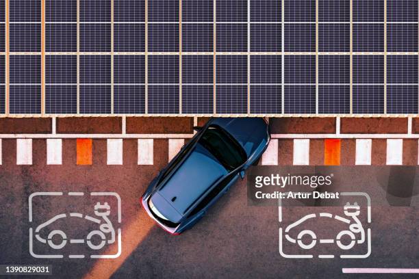 aerial view of electric car parking in charging station with solar panels. - auto batterie photos et images de collection