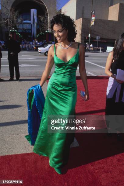 American actress Lela Rochon, wearing a green evening gown, and holding a blue shawl, attends the 1996 NAACP Image Awards, held at the Pasadena Civic...