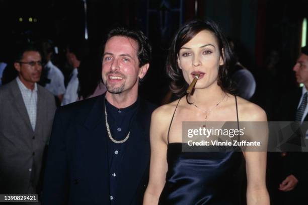 British author and playwright Clive Barker and Dutch actress Famke Janssen, smoking a cigar, attend the Hollywood premiere of 'Lord of Illusions,'...