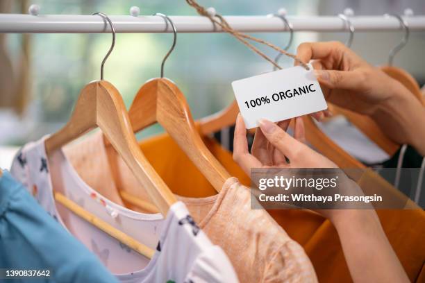 t-shirt made of 100% and hundred percent organic materials. customer with responsible and nature and eco friendly values. - shirt tag stock pictures, royalty-free photos & images