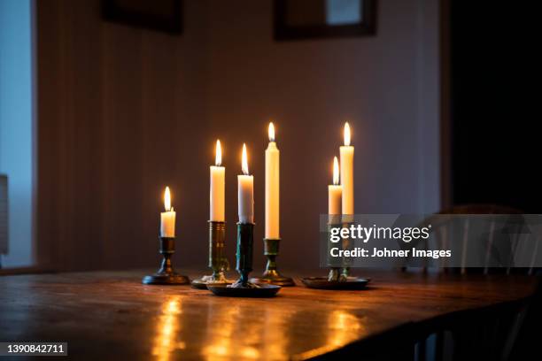 lit candles on wooden table - candlestick holder stock pictures, royalty-free photos & images