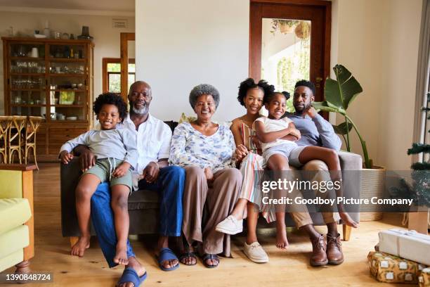 smiling multi-generation family sitting at home on christmas morning - family portait stock pictures, royalty-free photos & images