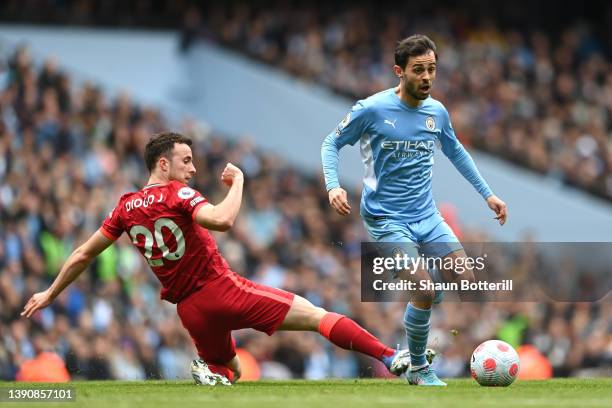 Bernardo Silva of Manchester City avoids a challenge from Diogo Jota of Liverpool during the Premier League match between Manchester City and...