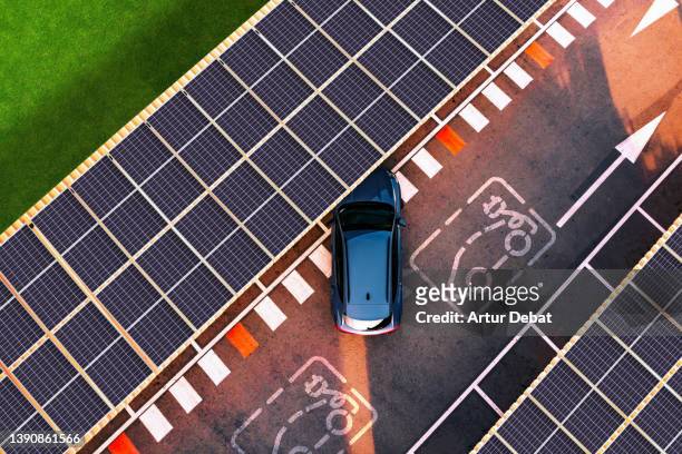 aerial view of electric car parking in charging station with solar panels. - solar power station stock-fotos und bilder