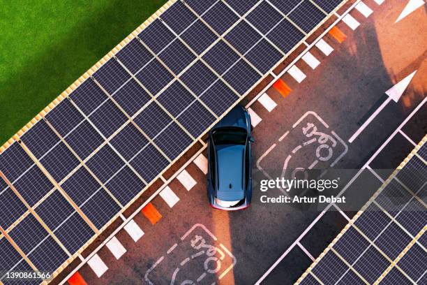 aerial view of electric car parking in charging station with solar panels. - solar powered station fotografías e imágenes de stock