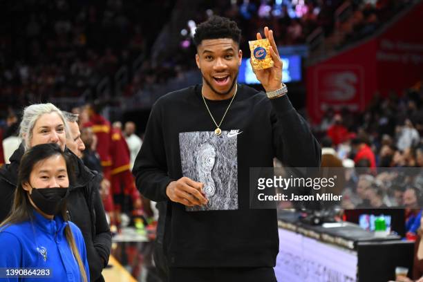 Giannis Antetokounmpo of the Milwaukee Bucks holds up a bag of popcorn during a timeout during the third quarter against the Cleveland Cavaliers at...