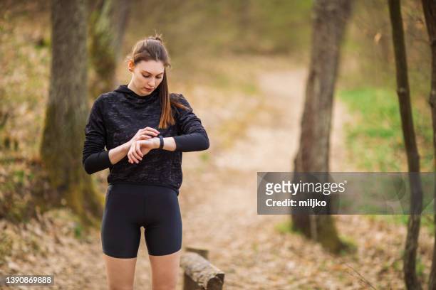young woman running and exercising outdoors - pedometer stock pictures, royalty-free photos & images