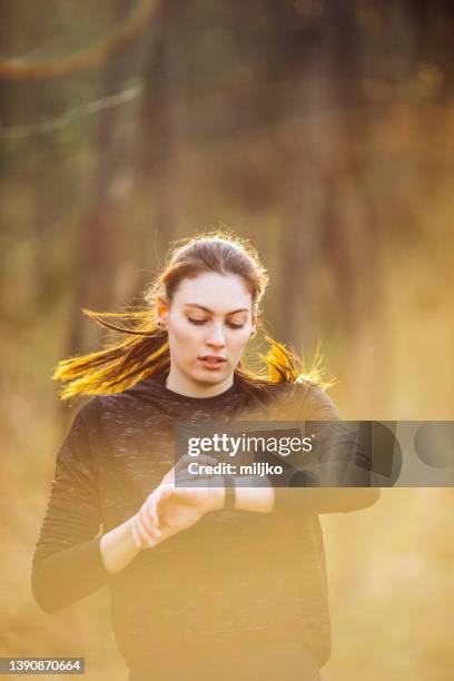 jeune femme qui court et fait de l’exercice à l’extérieur - podomètre photos et images de collection