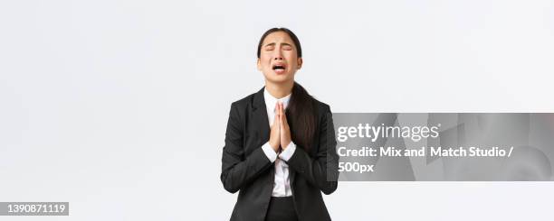 overworked and distressed asian businesswoman begging for help - begging stock pictures, royalty-free photos & images