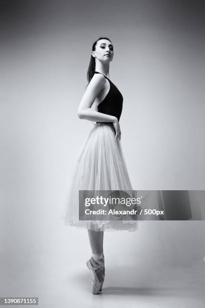 full length of young woman dancing against white background - full figure stock-fotos und bilder