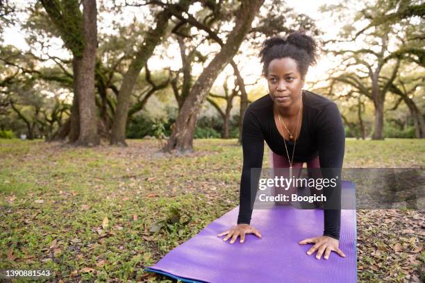 african american woman in 40s doing yoga in the park - meaningful stock pictures, royalty-free photos & images