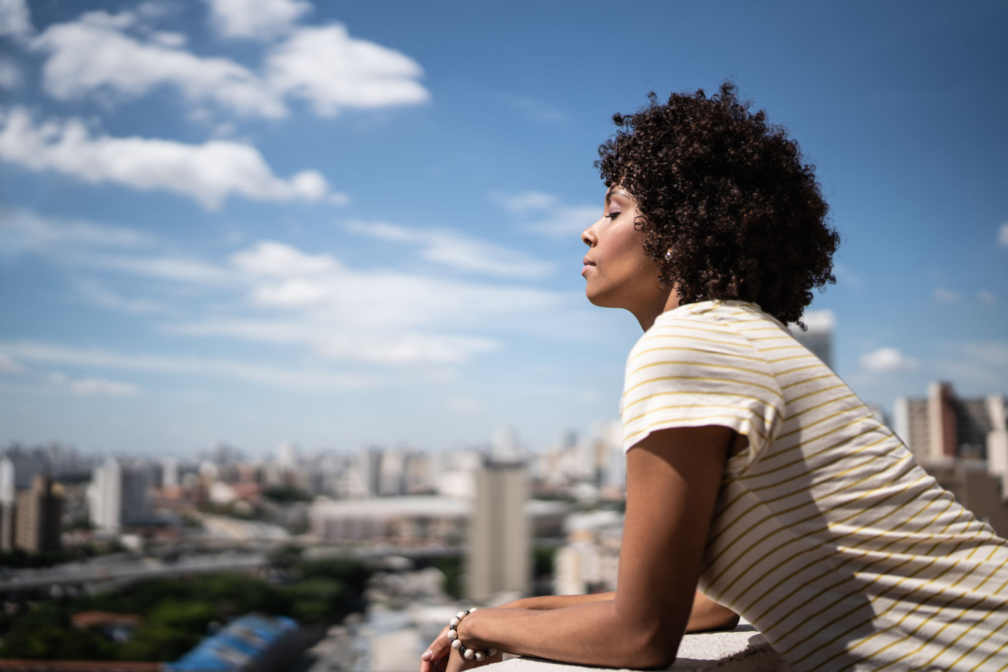 Young woman breathing with eyes closed on apartment's balcony Young woman breathing with eyes closed on apartment's balcony