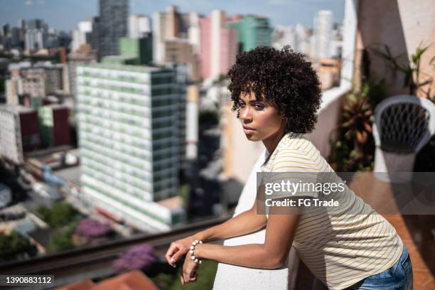 contemplative young woman on apartment's balcony - beauty woman outdoors stock pictures, royalty-free photos & images