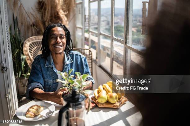 young man having breakfast with someone at home - dreadlocks stock pictures, royalty-free photos & images