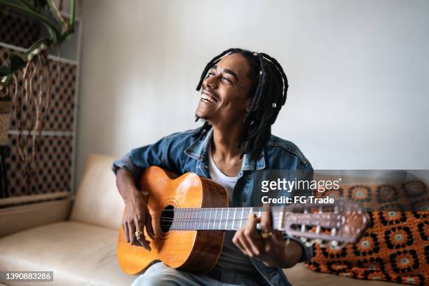 giovane che suona la chitarra a casa - musician foto e immagini stock