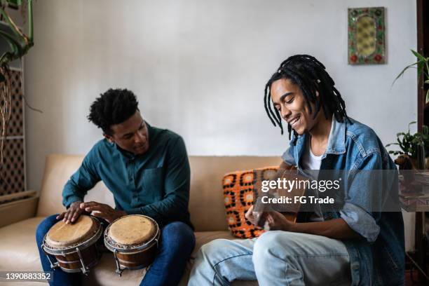 friends playing guitar and drums at home - reunion familia stock pictures, royalty-free photos & images