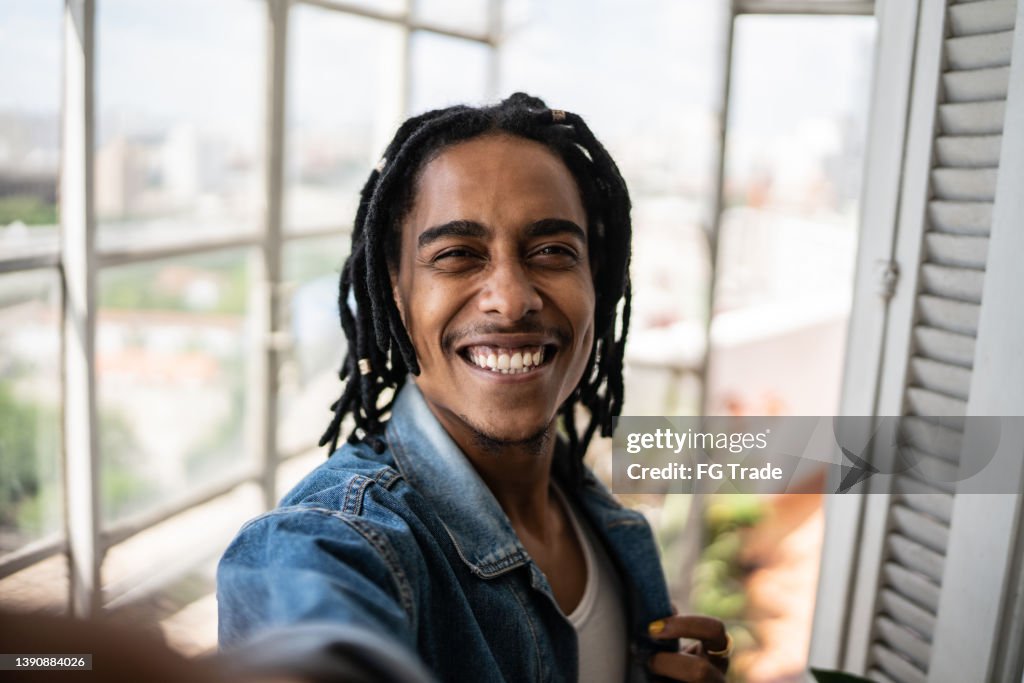 Young man on a taking selfie at home - camera point of view
