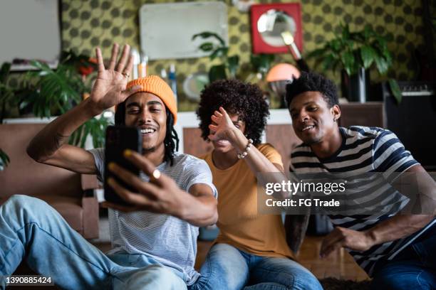 friends doing a video call using a smartphone at home - family webcam stock pictures, royalty-free photos & images