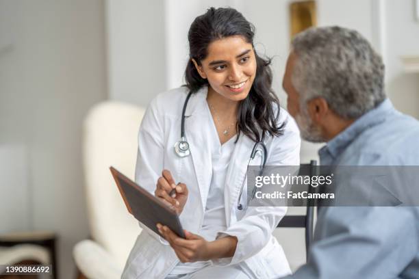 visita all'assistenza domiciliare con un signore anziano - adult patient with doctor and stethoscope foto e immagini stock