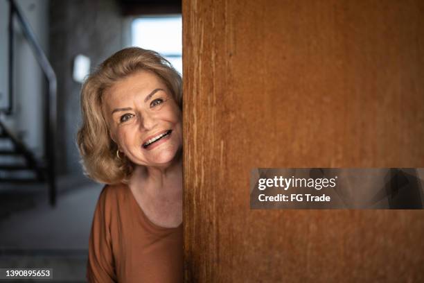 retrato de uma mulher idosa abrindo a porta - só uma mulher idosa - fotografias e filmes do acervo