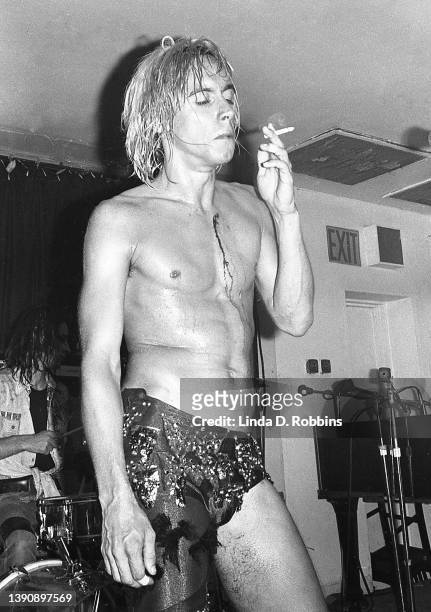 Iggy Pop smokes a cigarette onstage at Max's Kansas City after cutting his bare chest falling on a table, New York, 31st July 1973.