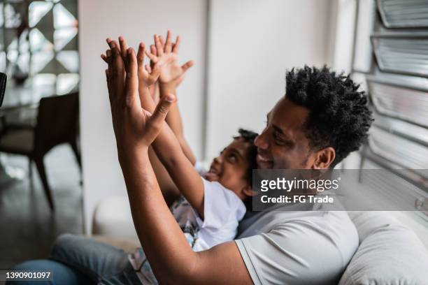father and son playing at home - clapping game stock pictures, royalty-free photos & images