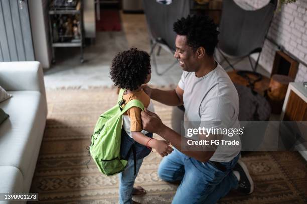 father helping son with backpack at home before leaving to school - school routine stock pictures, royalty-free photos & images