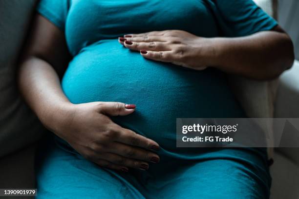 pregnant woman touching her belly - human abdomen bildbanksfoton och bilder