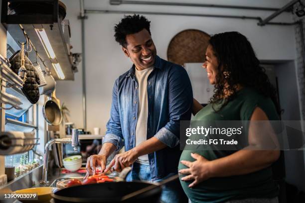 couple cooking together at home - black cook stockfoto's en -beelden