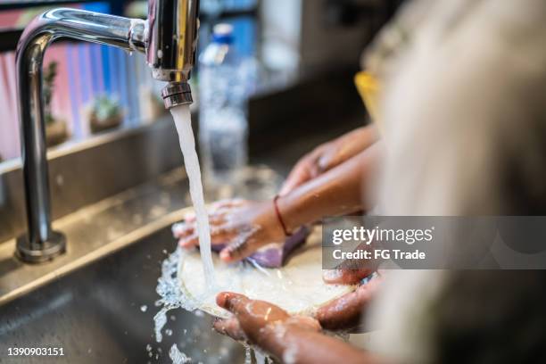 père et fils faisant la vaisselle à la maison - liquide vaisselle photos et images de collection