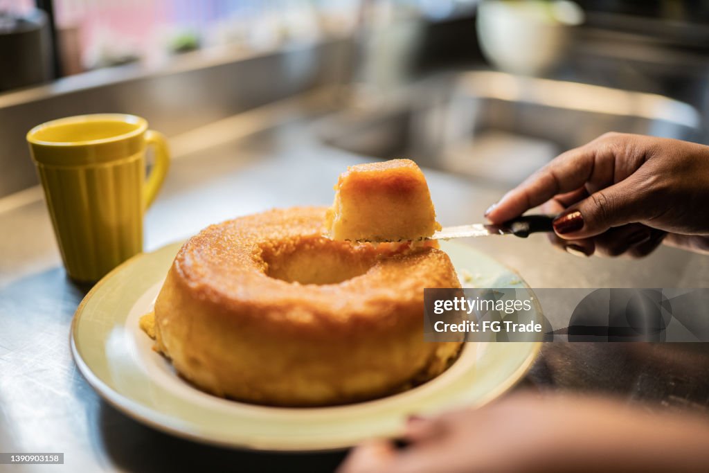 Female hands cutting a slice of pudim