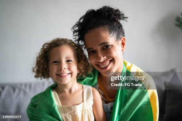 portrait of a mother and daughter with brazilian flag at home - brazil girls supporters stock pictures, royalty-free photos & images