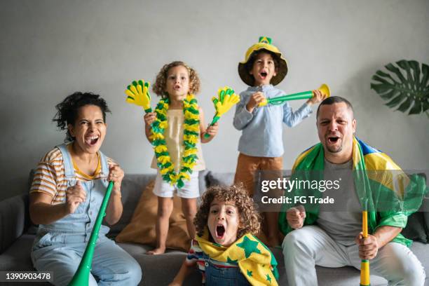 family celebrating brazilian soccer team goal at home - a brazil supporter stockfoto's en -beelden