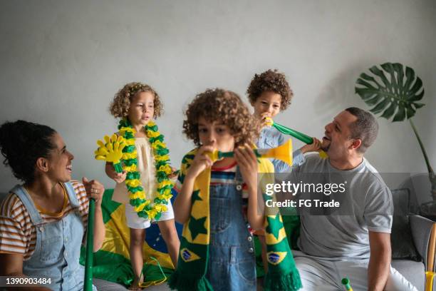 family cheering for brazilian soccer team at home - brazil girls supporters stock pictures, royalty-free photos & images