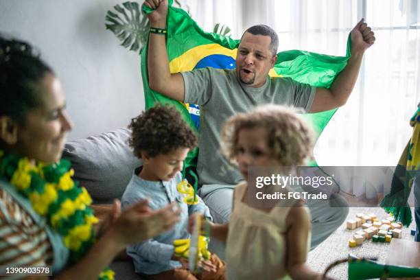 family cheering for brazilian soccer team at home - brazil girls supporters stock pictures, royalty-free photos & images