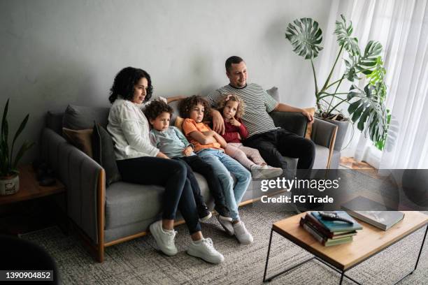 family watching tv at home - family tv stock pictures, royalty-free photos & images