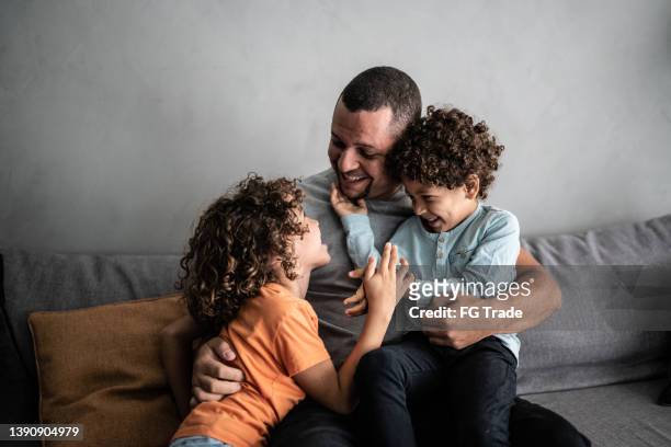 padre che gioca a fare il solletico con i figli a casa - family with two children foto e immagini stock