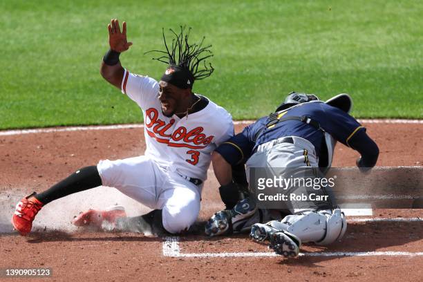 Jorge Mateo of the Baltimore Orioles scores a run as catcher Victor Caratini of the Milwaukee Brewers applies the late tag in the second inning...